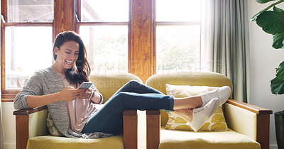 Buy stock photo Full length shot of an attractive young woman laughing while using a smartphone on her couch at home