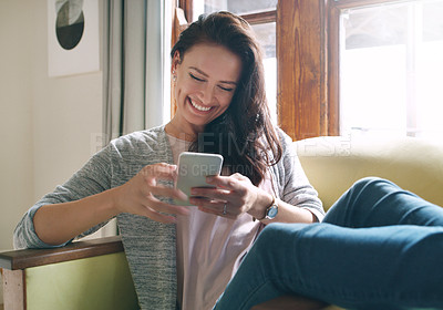 Buy stock photo Woman, phone and happy on sofa for reading text, social media and dating site registration in home. Female person, mobile and smile for chat app with networking, communication and online blog update