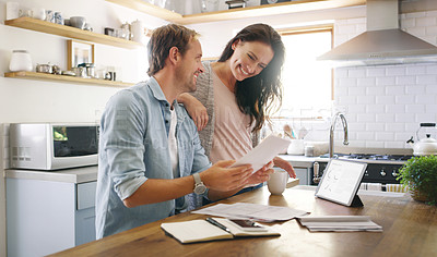 Buy stock photo Cropped shot of an affectionate young couple looking cheerful while going through their budget at home