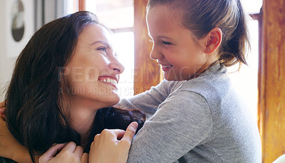 Buy stock photo Cropped shot of an affectionate young mother smiling at her daughter while spending time with her at home