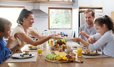 Buy stock photo Cropped shot of two affectionate young parents having breakfast with their  kids in the kitchen at home