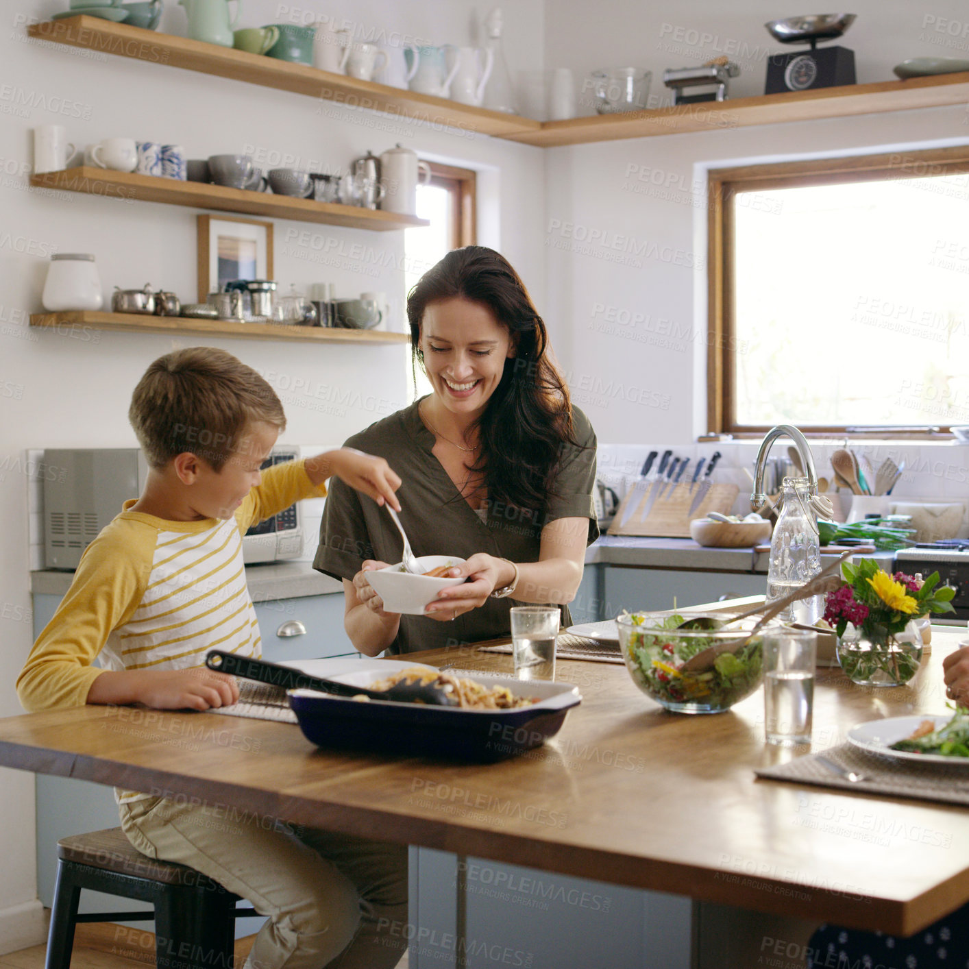 Buy stock photo Happy woman, child and serving dinner with kitchen, meal and food for holiday or vacation. Excited, people and table with hungry as family, mom and kid for nutrition, bonding and healthy diet in home