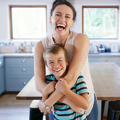 Buy stock photo Cropped portrait of an affectionate young mother looking ecstatic while holding her son in their kitchen at home