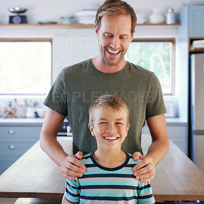 Buy stock photo Cropped shot of an affectionate young father looking cheerful while standing with his son in their kitchen at home