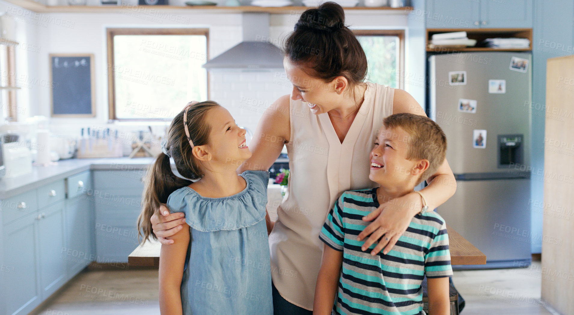 Buy stock photo Cropped shot of an affectionate young mother spending time with her two kids in their kitchen at home