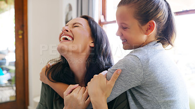 Buy stock photo Cropped shot of an affectionate young mother laughing while spending time with her daughter at home