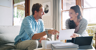Buy stock photo Cropped shot of an affectionate young couple laughing together while going through their budget at home