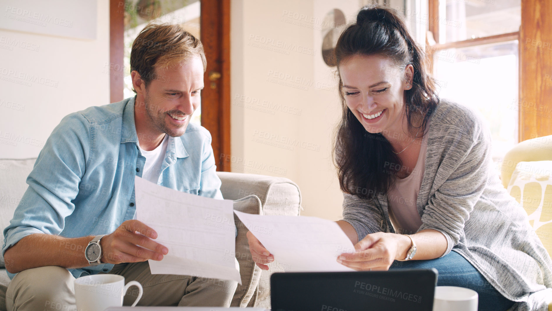 Buy stock photo Cropped shot of an affectionate young couple smiling while going through their budget at home