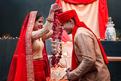 Buy stock photo Celebration, young Indian married couple happy and at wedding or special event. Festival or romance, culture or marriage and smiling people with woman putting necklace on man neck with veil.