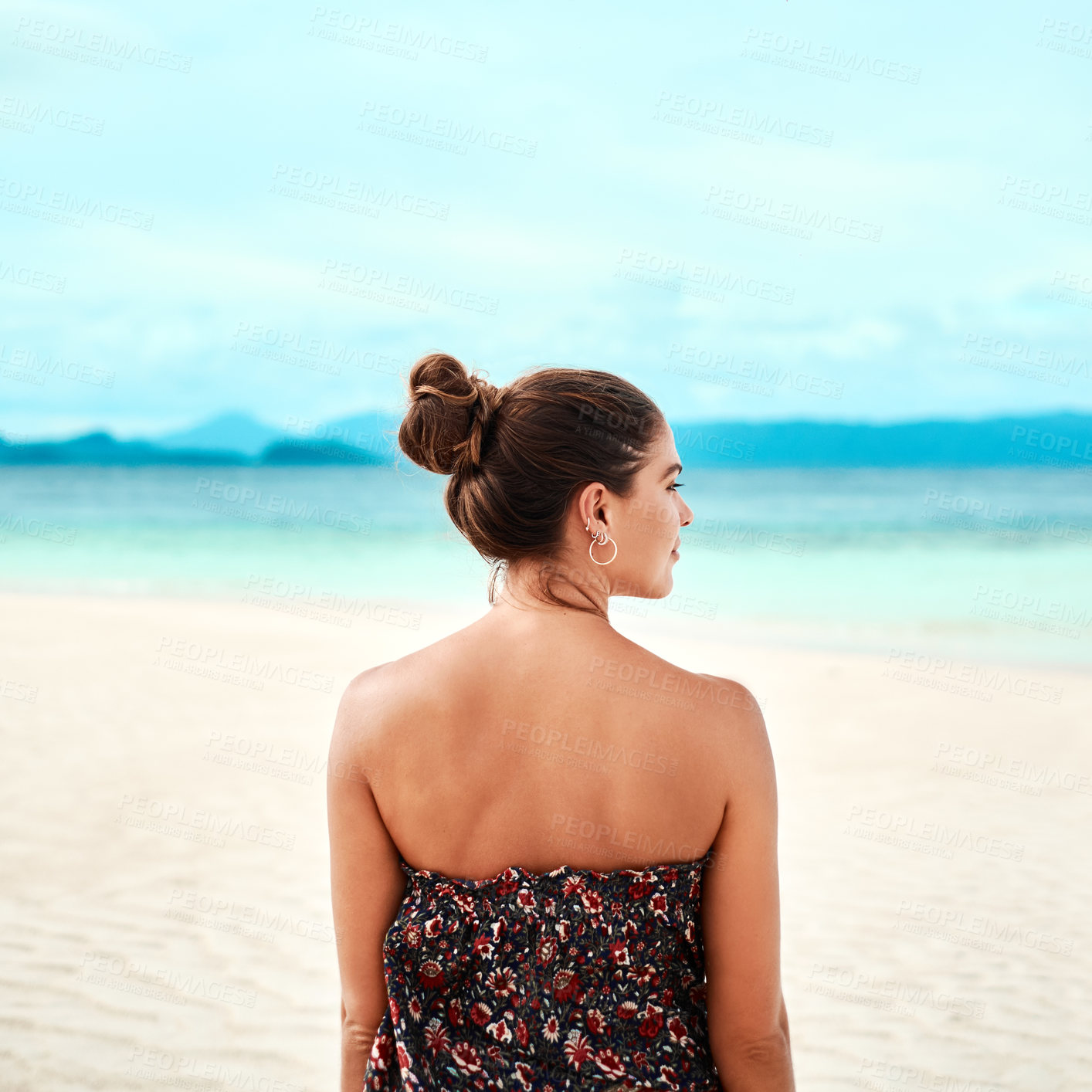 Buy stock photo Rearview shot of a young woman spending the day at the beach