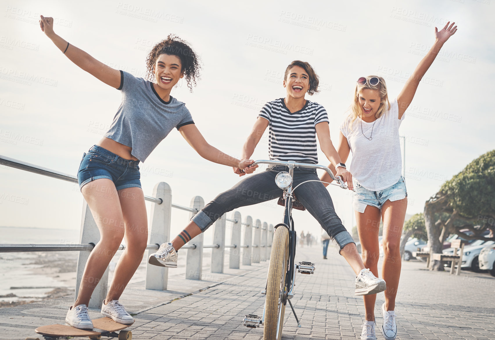 Buy stock photo Cycling, friends and skateboard with women in summer for sports, fun and holiday break. Health, joy and wellness with group helping bike on promenade for relaxing, Miami travel and freedom together