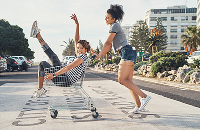 Buy stock photo Friends, girls and play on trolley outdoor for fun, bonding and transport ride of balance support in summer. People, freedom and smile with shopping cart for travel activity, relax and road together
