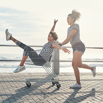 Buy stock photo Friends, girls and fun with trolley outdoor for freedom, bonding and transport ride of beach travel in summer. People, women and smile with shopping cart for play activity, relax and ocean together