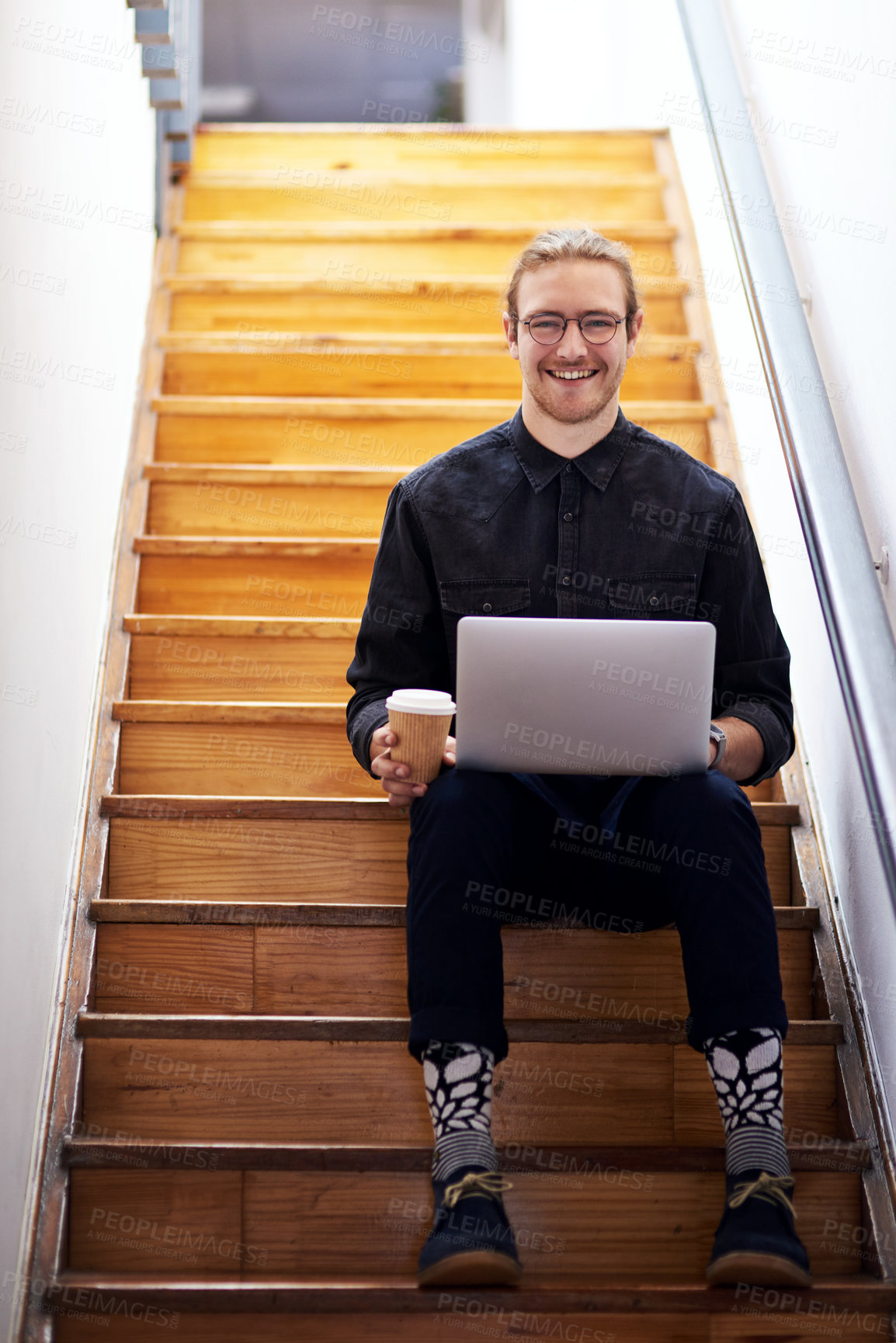 Buy stock photo Full length portrait of a handsome young businessman sitting alone on the staircase alone and using his laptop