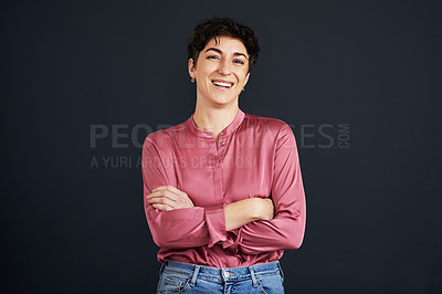 Buy stock photo Cropped portrait of an attractive young businesswoman standing alone with her arms folded against a black background in the studio