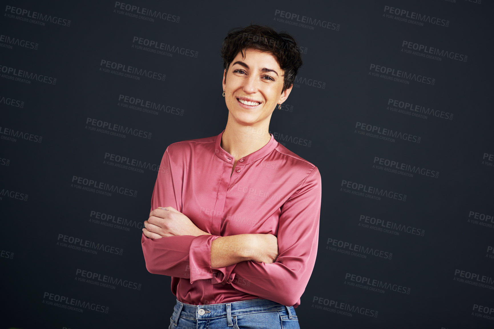 Buy stock photo Cropped portrait of an attractive young businesswoman standing alone with her arms folded against a black background in the studio