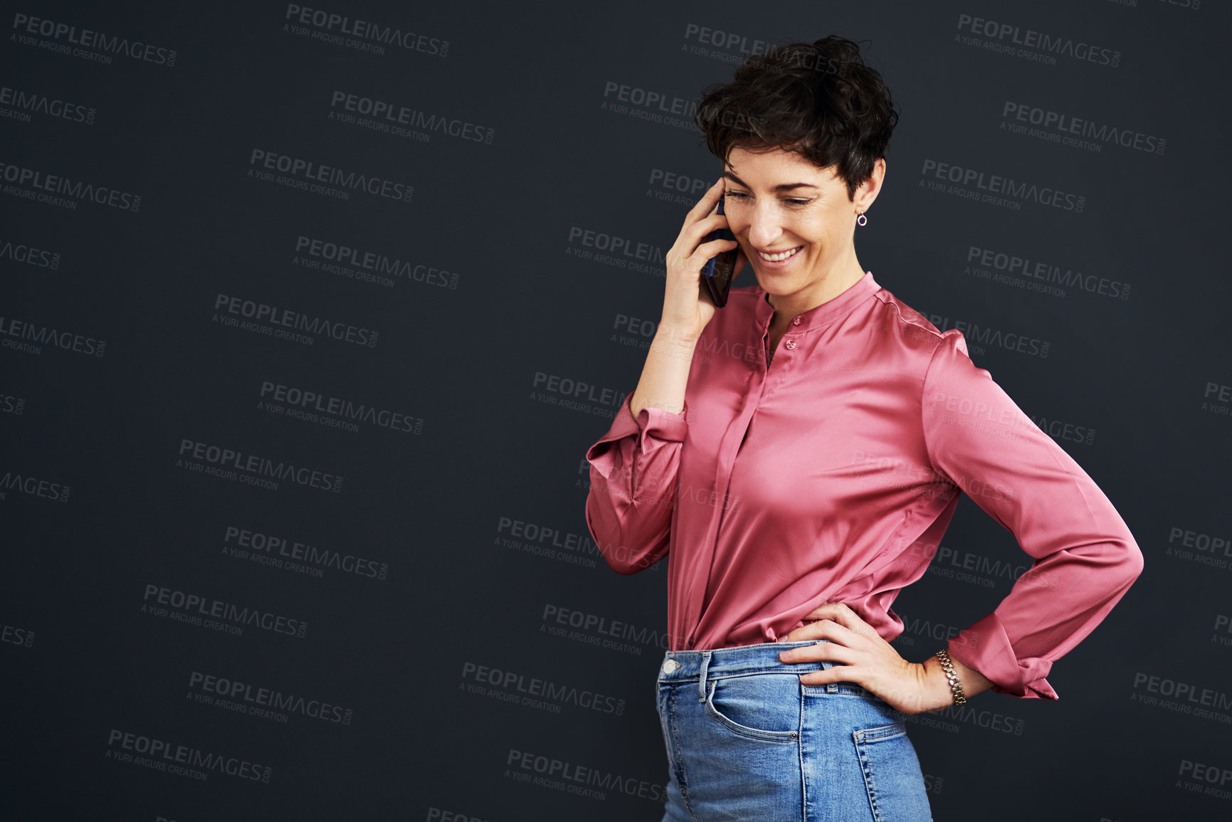 Buy stock photo Cropped shot of an attractive young businesswoman standing and talking on her cellphone against a black background in the studio