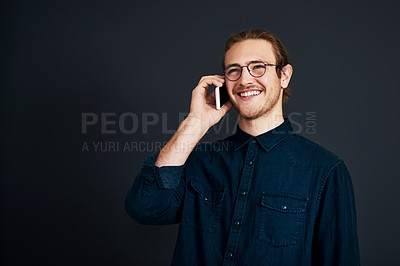 Buy stock photo Man, fashion and happy on phone call in studio for communication or networking on dark background. Male person, mockup space and smile or satisfied in style for conversation, gossip or connection