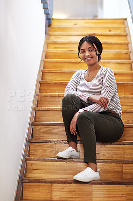 Buy stock photo Full length portrait of an attractive young businesswoman sitting alone on a wooden staircase in her office
