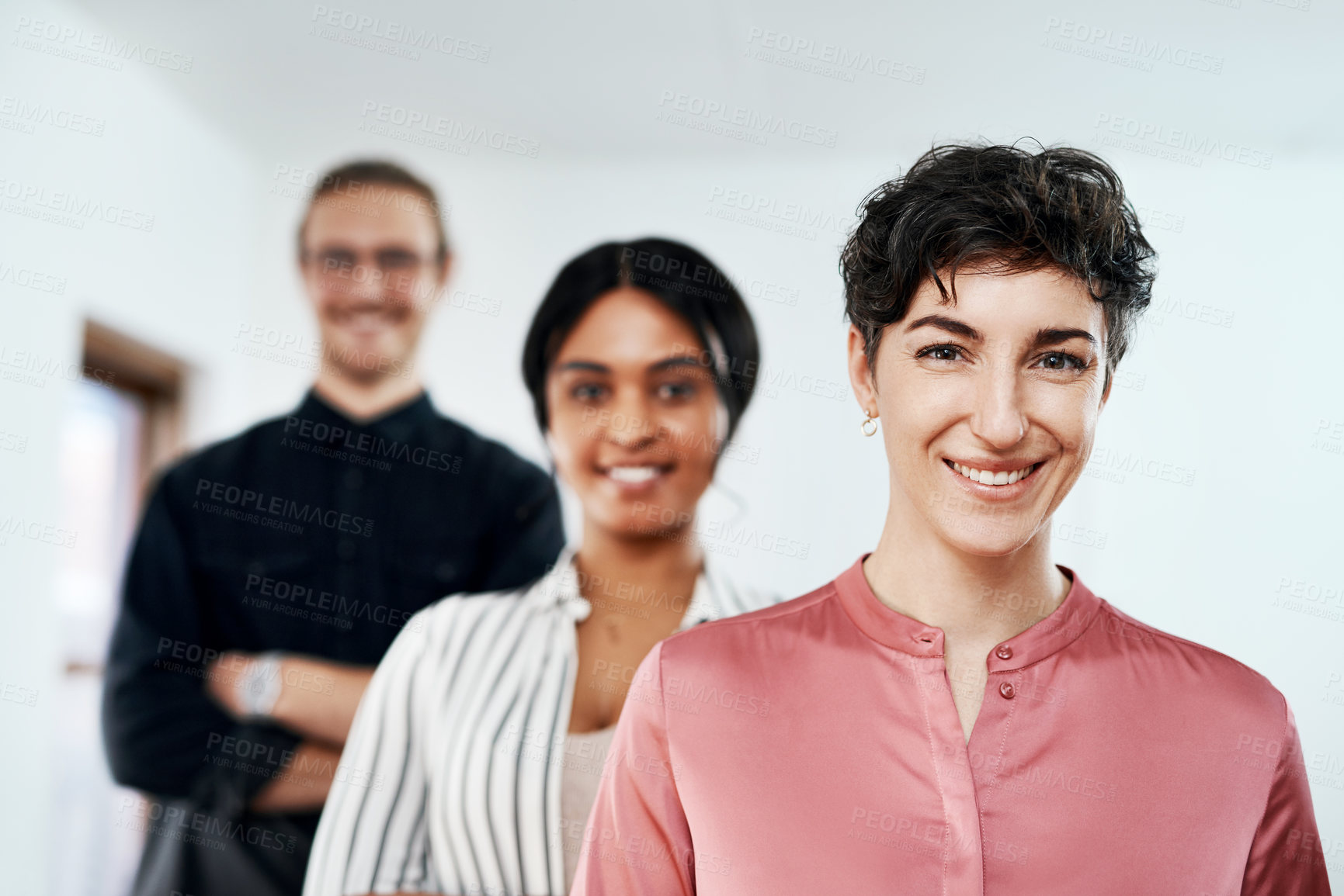 Buy stock photo Cropped portrait of a diverse group of businesspeople smiling and standing in a line in the office