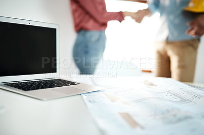 Buy stock photo Cropped shot of two unrecognizable businesspeople shaking hands in agreement over building plans in the office