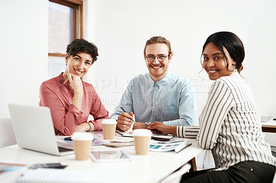 Buy stock photo Cropped portrait of a diverse group of businesspeople sitting together and smiling during a successful meeting in the office