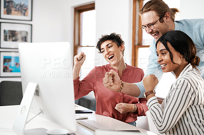 Buy stock photo Cropped shot of a diverse group of businesspeople celebrating while working on a computer together in the office