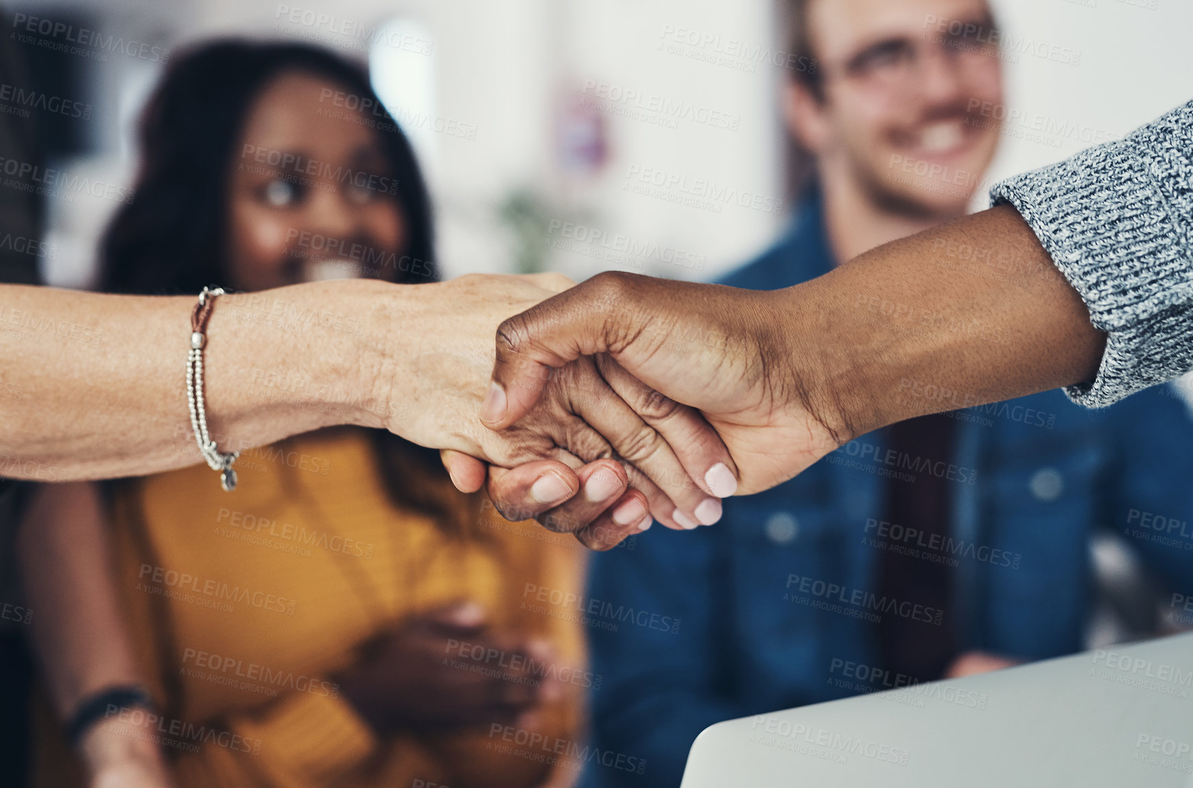 Buy stock photo Closeup of two unrecognizable businesspeople shaking hands in agreement inside of the office during the day
