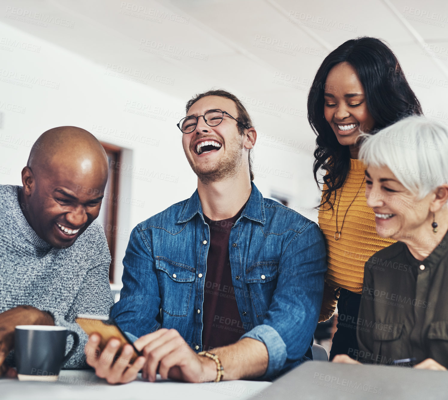Buy stock photo Cropped shot of a group of cheerful businesspeople browsing on a cellphone together inside of the office during the day