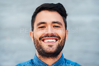 Buy stock photo Closeup portrait of a handsome young man smiling while standing against a brick wall