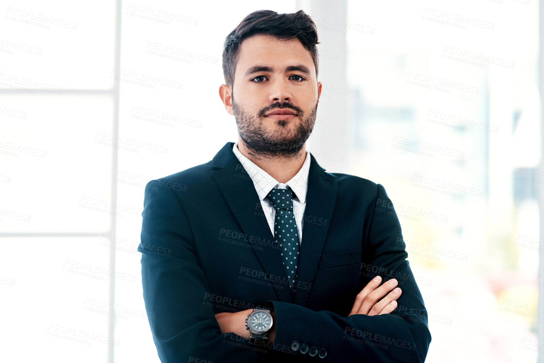 Buy stock photo Cropped portrait of a handsome young businessman standing with his arms crossed in a modern office