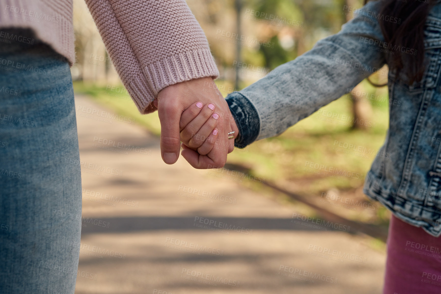 Buy stock photo Cropped shot of a little girl holding her mother’s hand while going for a walk in the park