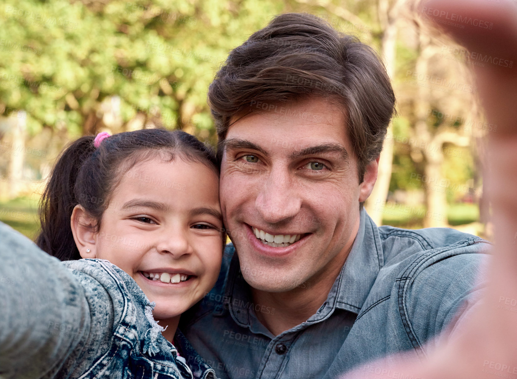 Buy stock photo Shot of a happy young man taking a selfie with his adorable daughter in the park