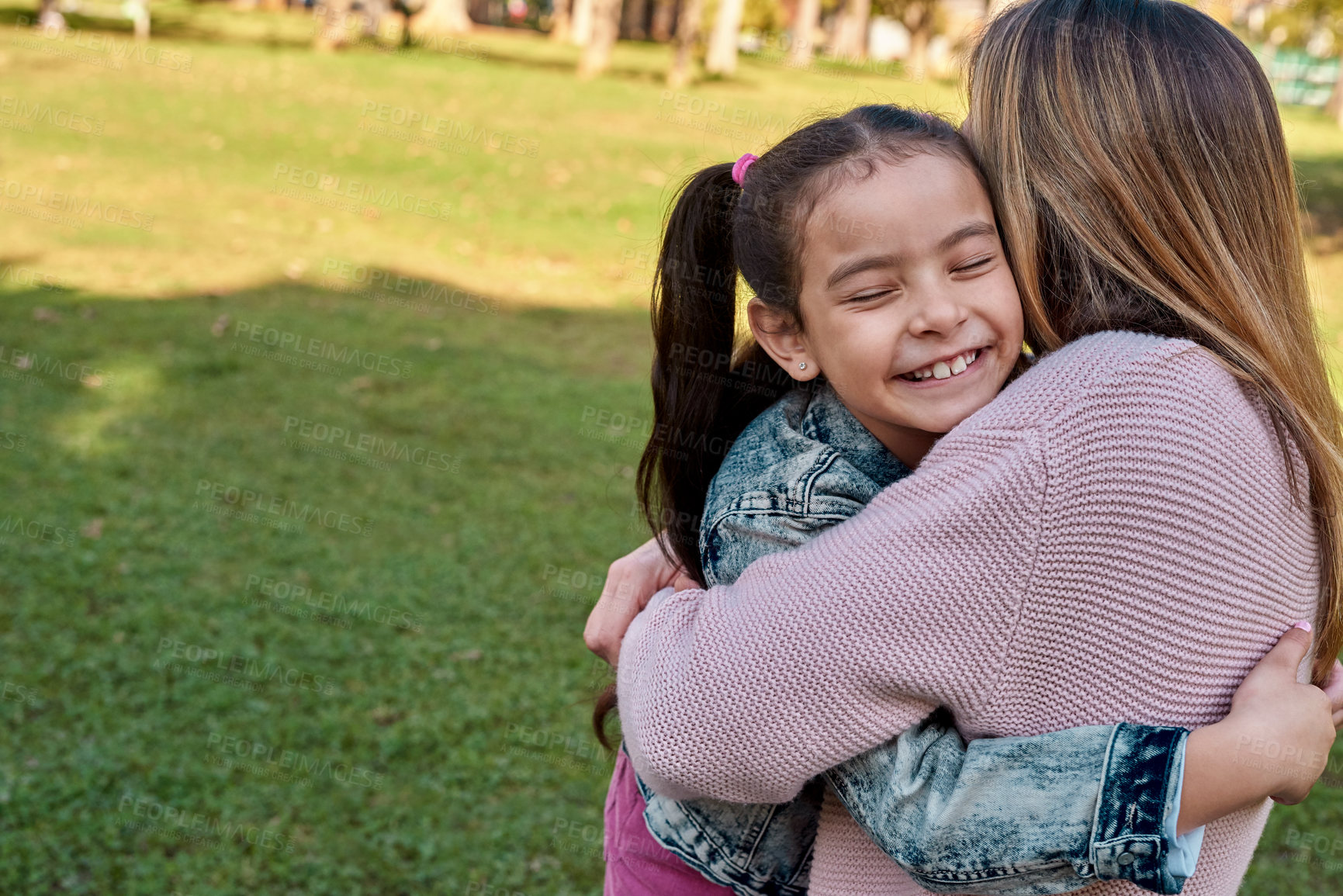 Buy stock photo Shot of an adorable little girl embracing her mother at the park