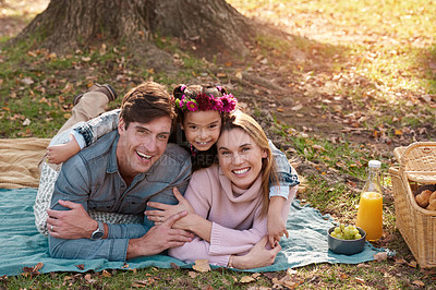 Buy stock photo Shot of a happy young family enjoying a picnic in the park