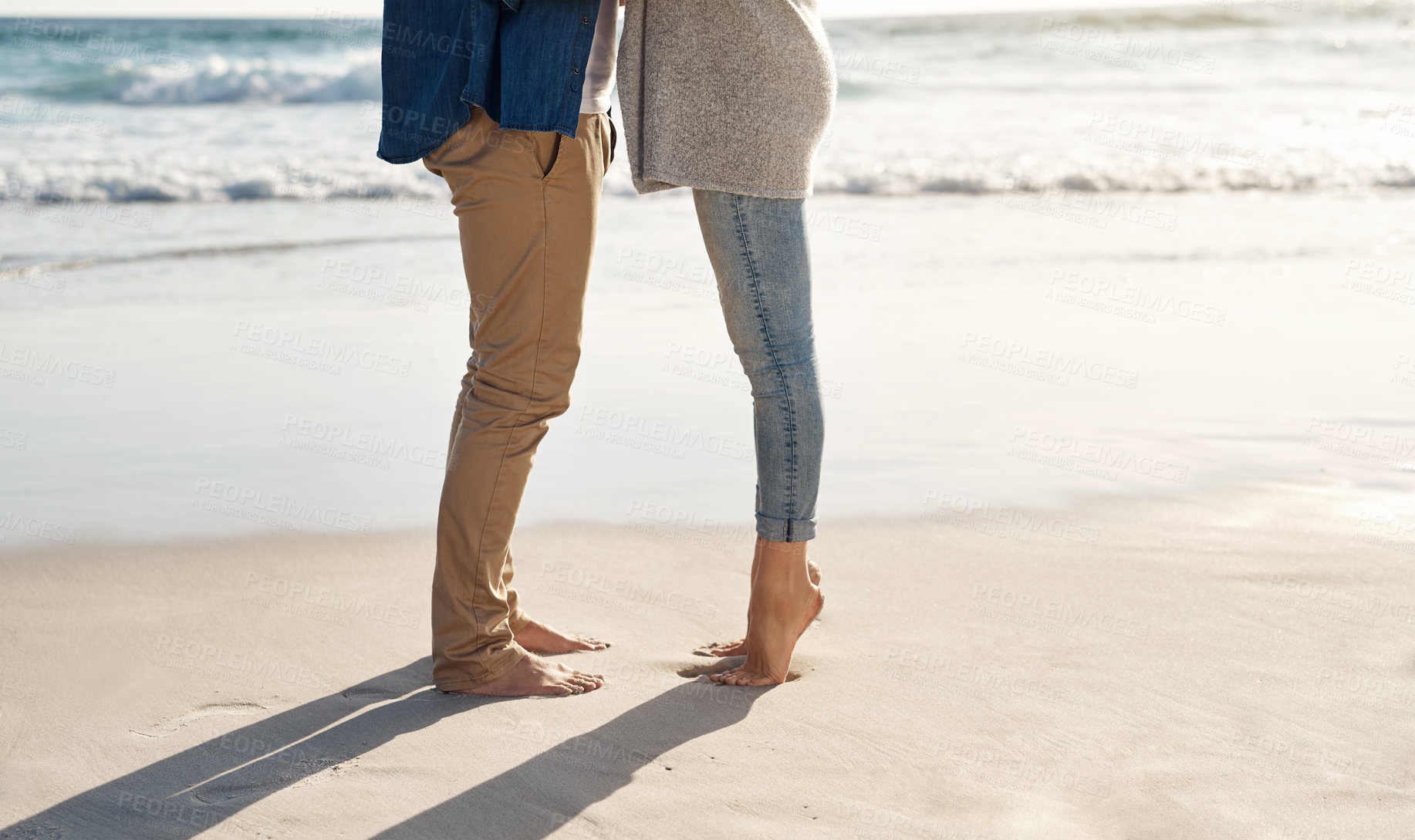 Buy stock photo Couple, legs and sand at beach with water for sunshine, holiday romance, love together and honeymoon travel. Woman, man and feet in ocean for summer vacation, wellness and relationship in Argentina