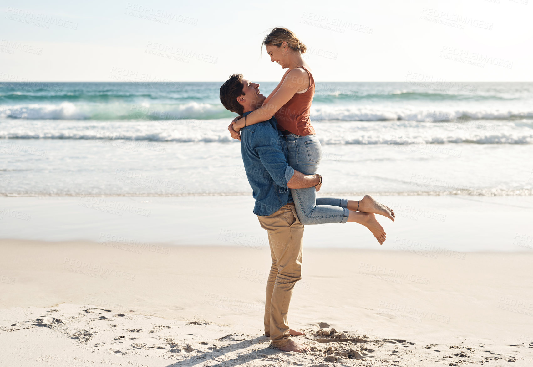 Buy stock photo Couple, happy and lifting at beach with love, summer and travel for vacation by ocean. Man, woman and hug at sea on sand with romance, smile and freedom or peace for holiday by water in Greece