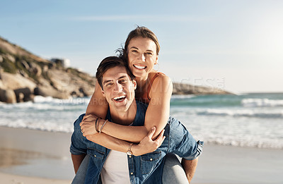 Buy stock photo Young couple, portrait and piggyback at beach in summer sunshine with love, romance and bonding with travel. Man, woman and happy with hug, ocean waves and smile in nature, outdoor and vacation
