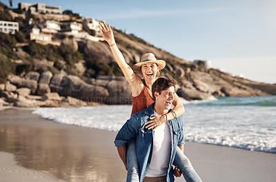 Buy stock photo Couple, piggyback and happy at beach with love, summer and travel for vacation by ocean. Man, woman and back ride  on sand in portrait with romance, smile and freedom for holiday by water in Greece