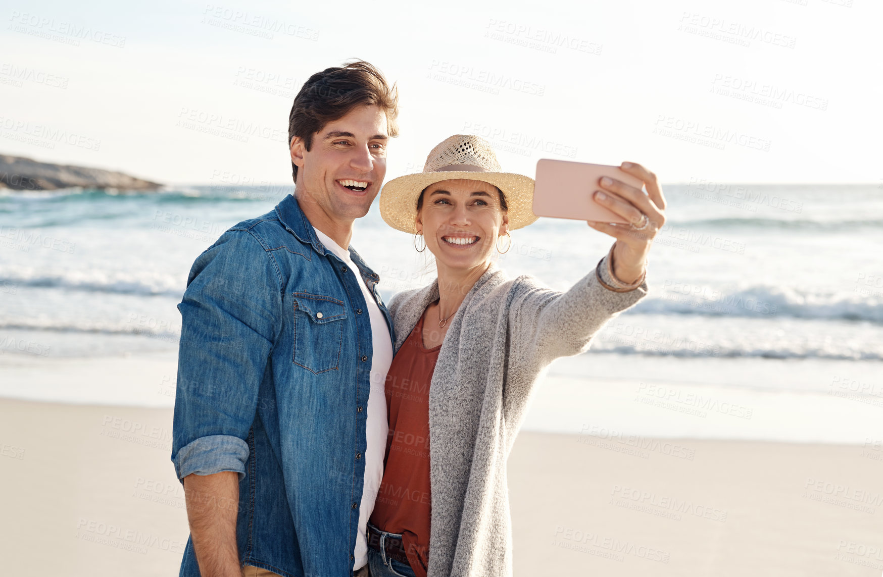 Buy stock photo Young couple, beach selfie and smile in summer sunshine for love, romance or happy for social media post. Man, woman and profile picture for blog, app or internet by ocean, waves or sea for vacation