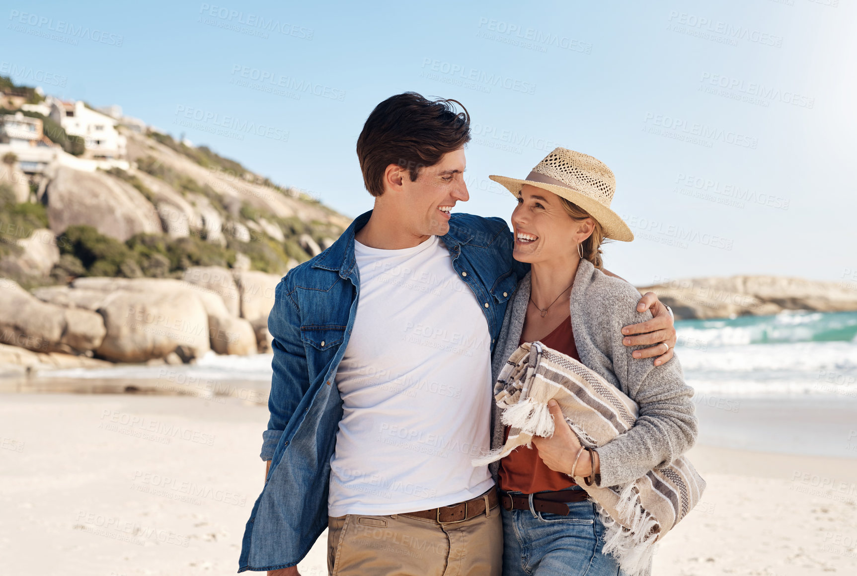 Buy stock photo Love, happy couple at the beach and walking together hugging on seashore, Summer vacation or holiday break, adventure or traveling journey and young people walk at sea for fresh air with blue sky