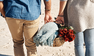 Buy stock photo Couple, beach and picnic basket with flowers in walking, back and holiday for vacation, ocean and cropped shot.  Romantic, summer and red roses, bonding and sea or outdoor, sand and romance in love