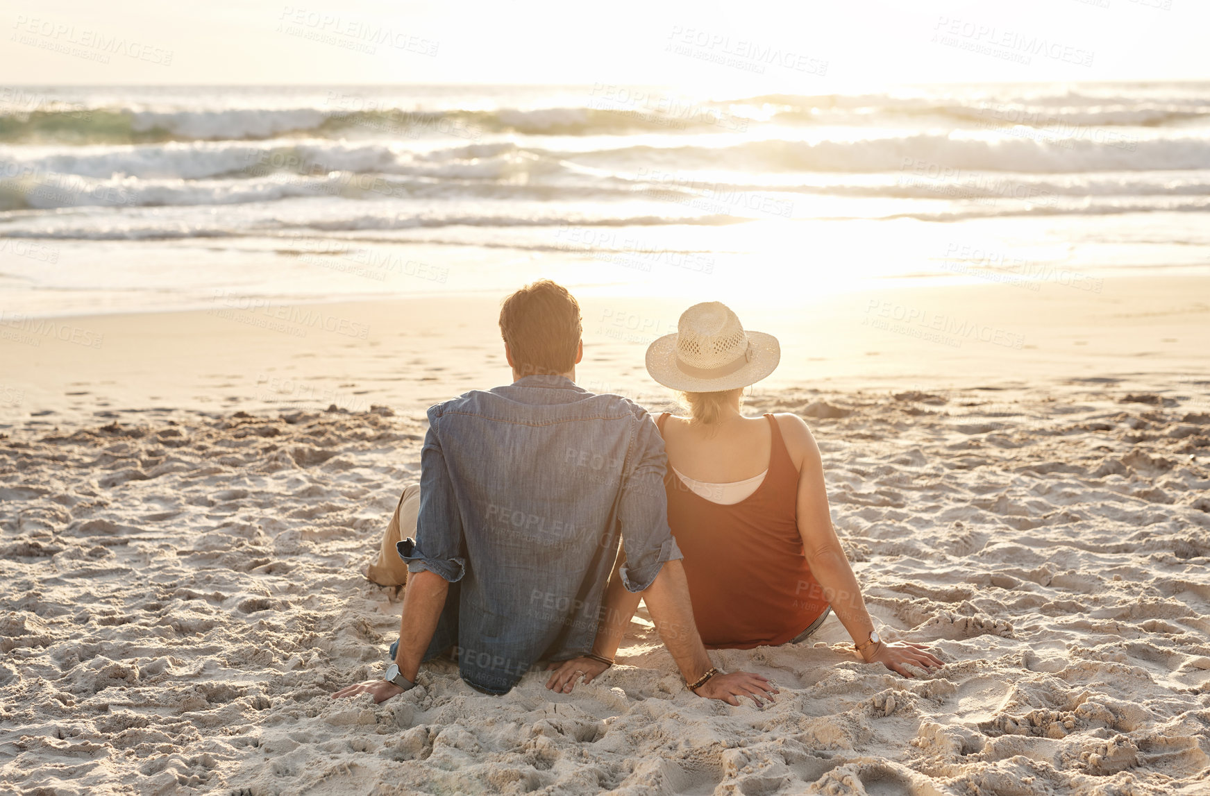 Buy stock photo Couple, vacation or beach trip sitting on blanket for picnic or relaxing on seashore getaway. Love, man and woman together happy in nature by ocean for romantic date, sunset or holiday in California