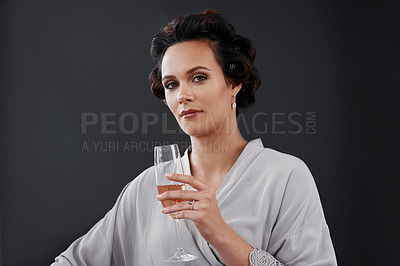 Buy stock photo Cropped shot of a woman drinking champagne while getting ready