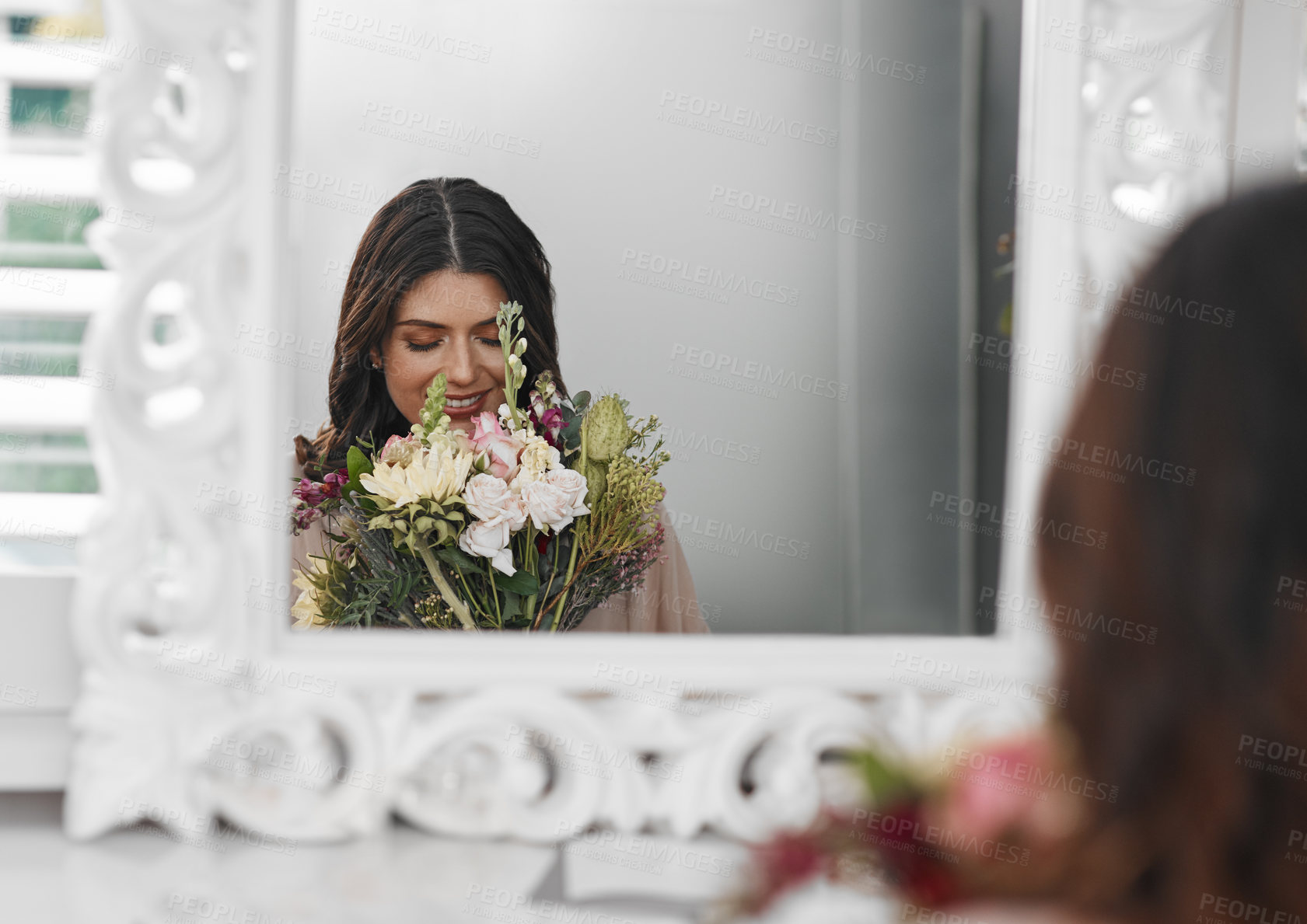 Buy stock photo Cropped shot of a beautiful woman smelling flowers while sitting in front of the mirror