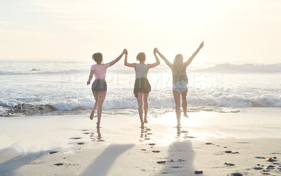 Buy stock photo Shot of three friends spending the day at the beach
