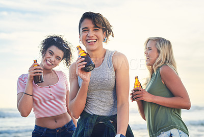 Buy stock photo Shot of three friends enjoying drinks while on the beach
