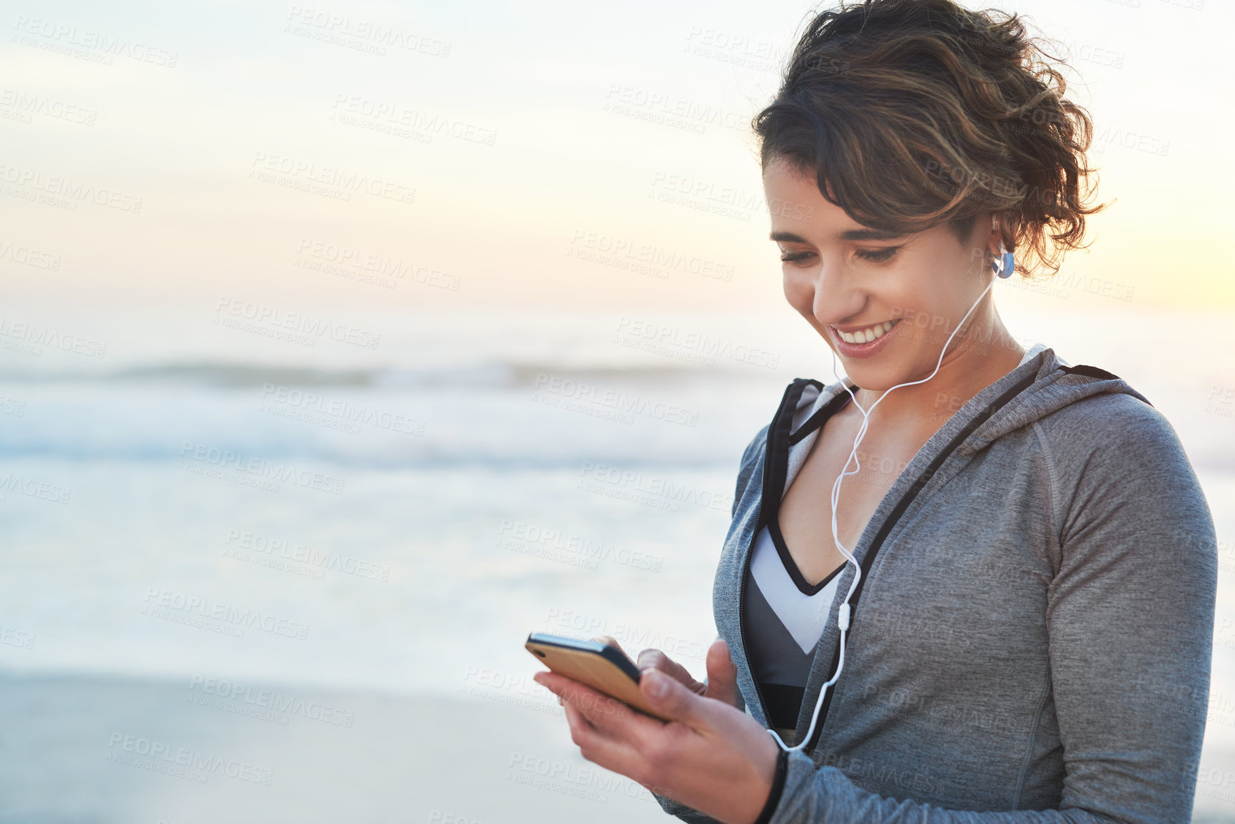 Buy stock photo Shot of a woman using her cellphone while out for a run