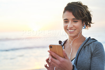 Buy stock photo Shot of a woman using her cellphone while out for a run