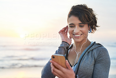 Buy stock photo Happy woman, cellphone and music on beach for fitness, wellness and goals track on break. Mockup space, female person and earphones with mobile app for podcast, radio and motivation for exercise